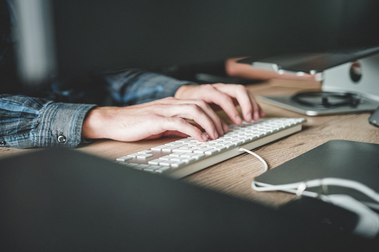 A person typing on a keyboard implementing a professional services automation tool for their business.